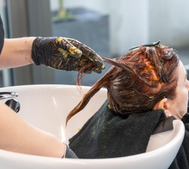 Foto zeigt Frau beim Friseur, die neue Haarfrabe bekommt im Waschbecken