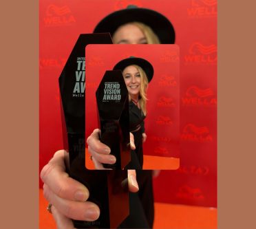 Kim Duerr hält National Trend Vision Award-Trophäe in die Kamera