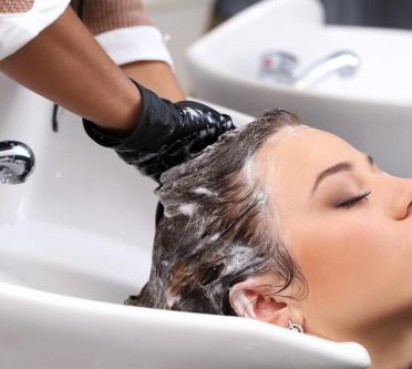 Friseur wäscht Frau die Haare