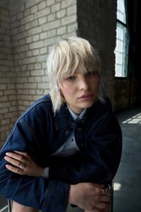 Trend Alcina 2 Blonder Mullet mit fransig geschnittenem Pony, kurzen Seitenpartien und längerem Nackenhaar in lässig strukturierter Optik.