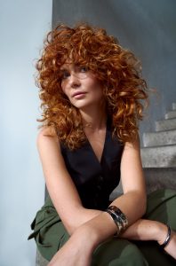 Trend Alcina 3 Kupferfarbener Shag mit üppigen Locken, viel Volumen und rund um das Gesicht gestuften Partien.