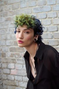 Trend Alcina 8 Kurzer Lockenlook mit dunkler Basis und markanten Farbpartien in leuchtendem Blau und Grün.