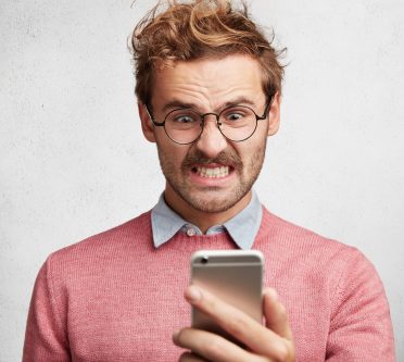 Mann schaut fristreit in sein Handy
