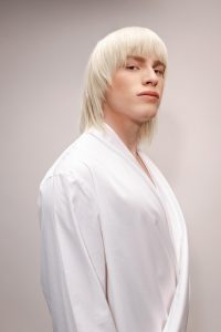 Trend Intercoiffure Austria 8 Platinblonder, stark konturierter Long Mullet mit Pony und längeren, fedrigen Strähnen im Nacken.