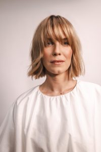 Trend Intercoiffure Austria 1 Gut kinnlanger, sanft gestufter Bob in warmem Blond-Braun mit langem, fransigem Pony und leicht bewegten Spitzen.