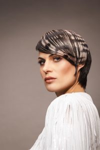 Trend Intercoiffure Austria 10 Selbstbewusster Pixie mit markantem Laserprint-Haardesign in dunklem Braun und Blond.