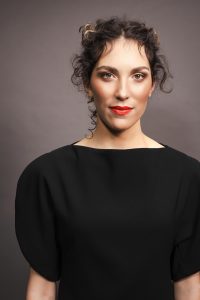 Trend Intercoiffure Austria 6 Dunkles, lockiges Haar locker hochgesteckt, mit feinen, offenen Strähnen rund um Gesicht und Nacken.