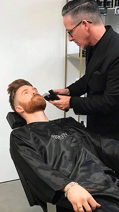 Friseur Jim Shaw rasiert einen Kunden